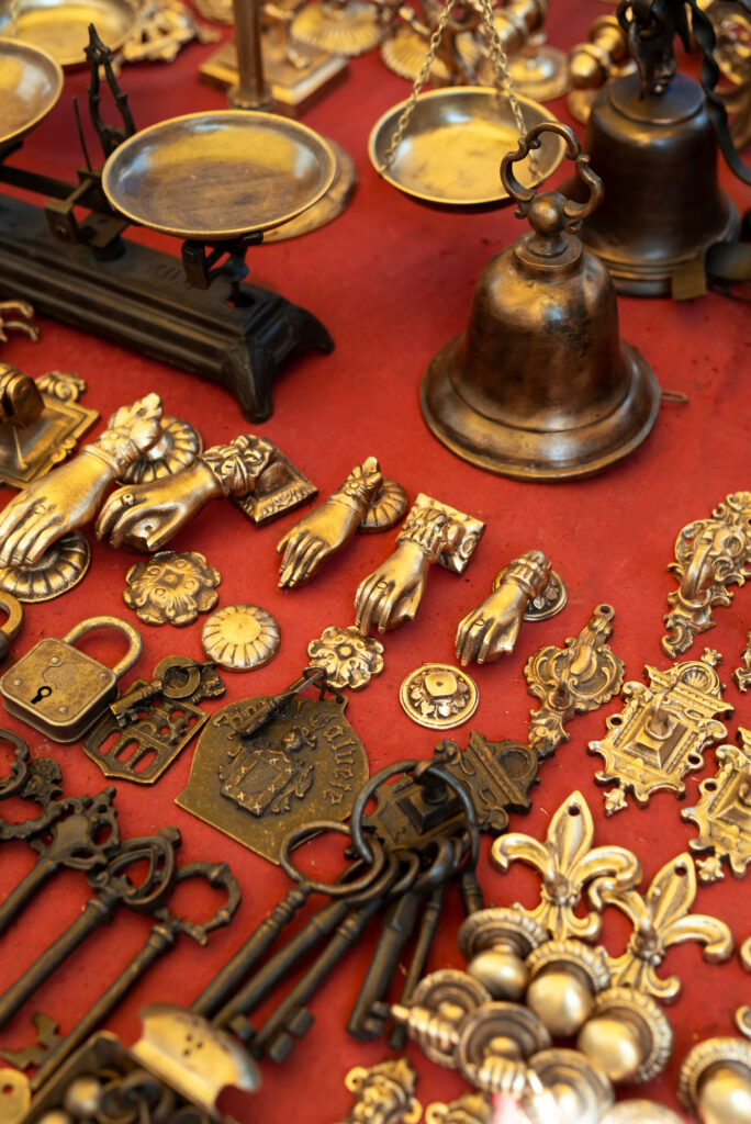 Antike Messingobjekte auf rotem Tuch.